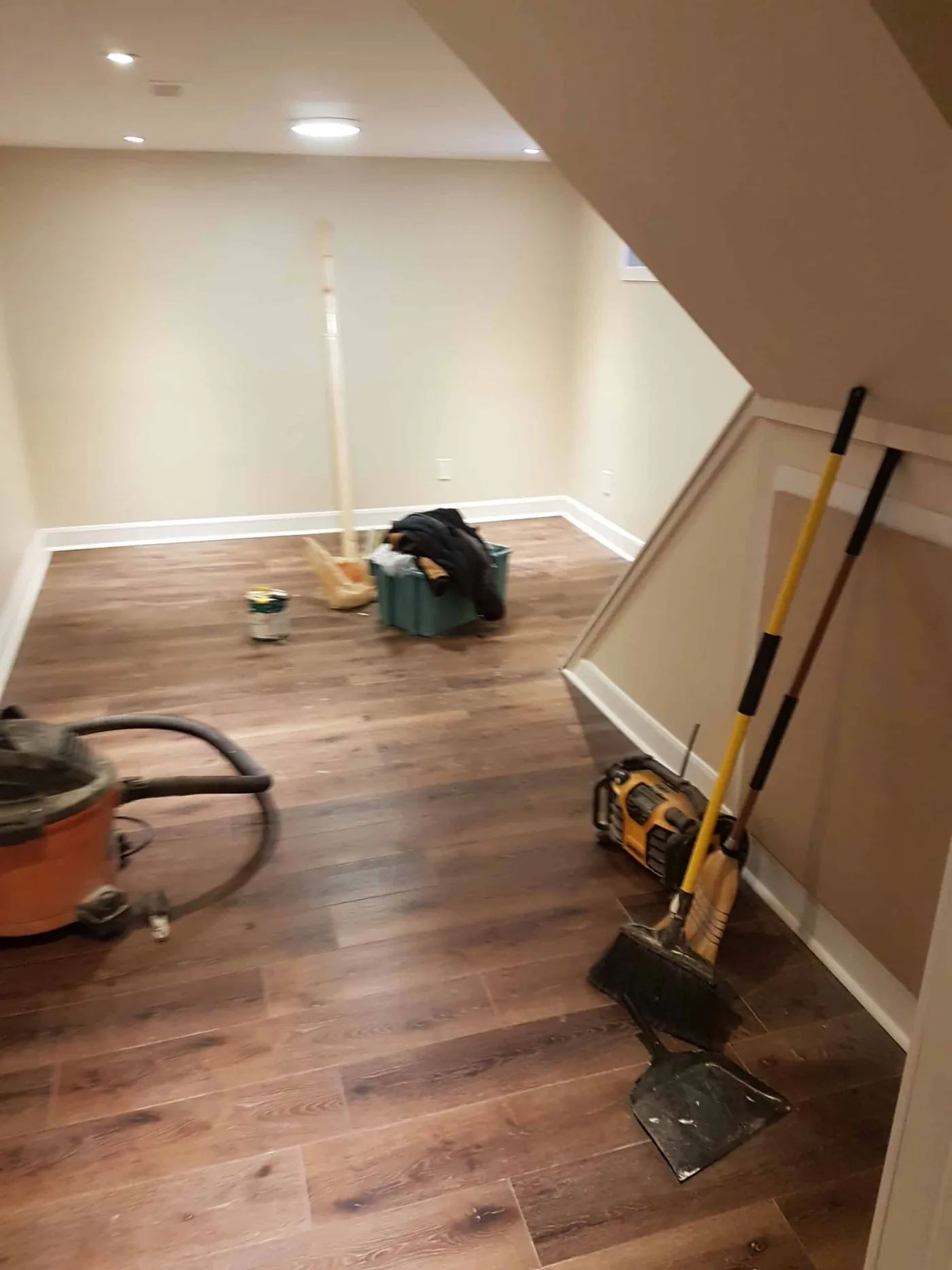 Lower-level room with an angled ceiling being prepared for paint