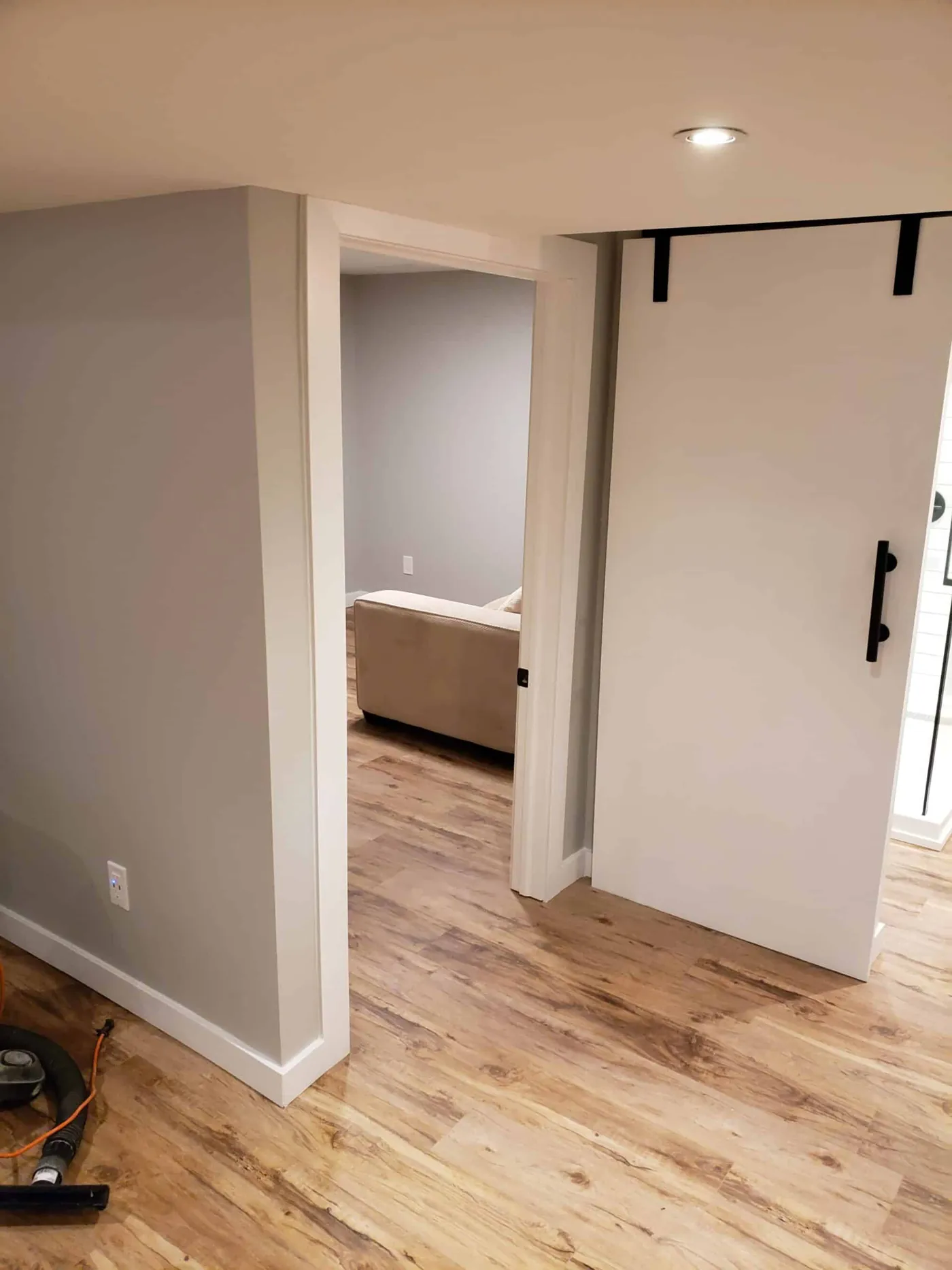 Painted lower-level room with a white sliding barn door