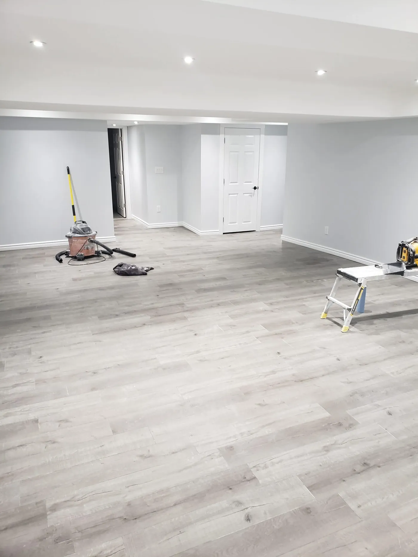 Open lower-level living space painted in a soft grey with white trim