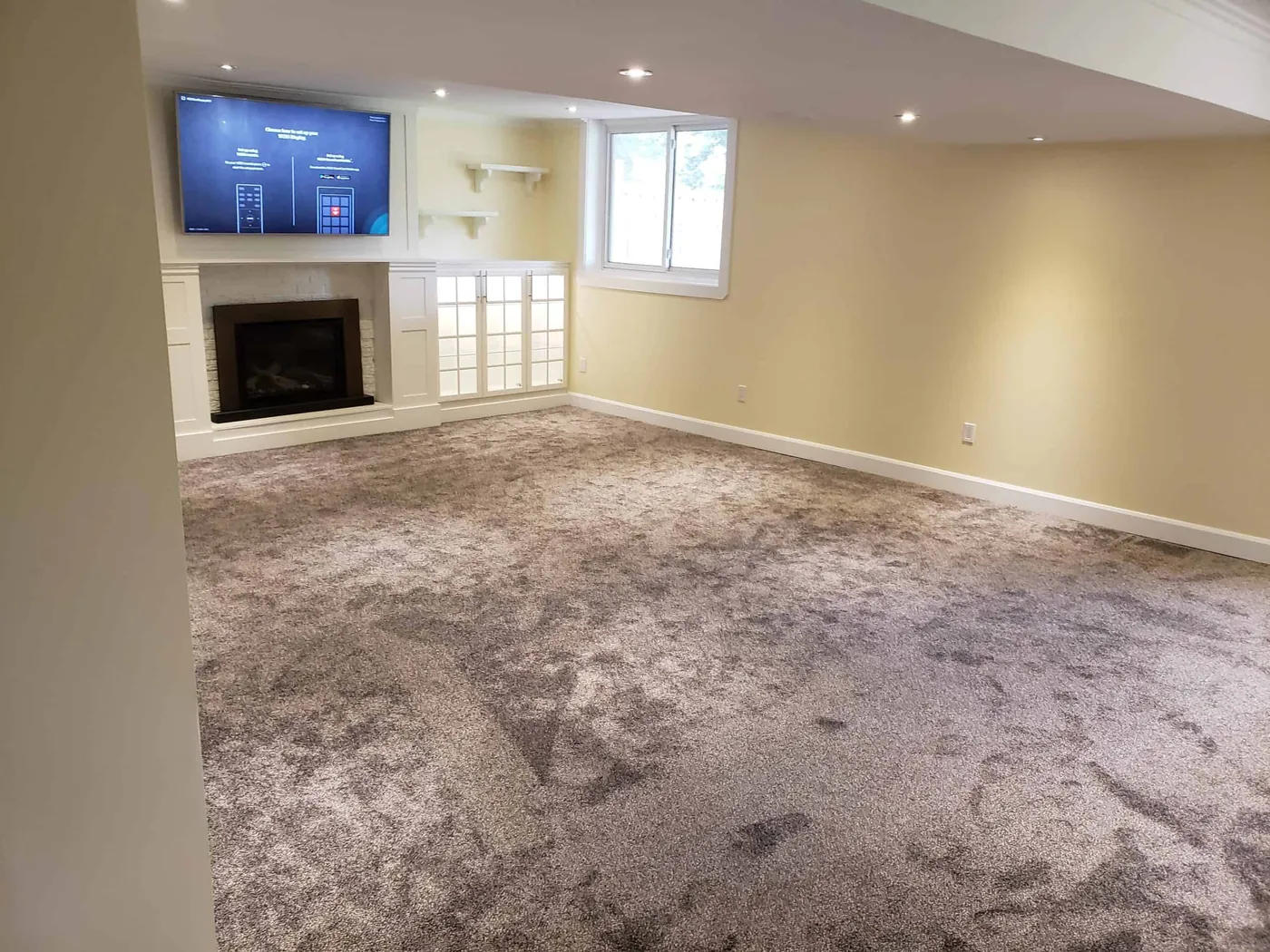 Rec room with a painted fireplace surround and built-in shelving
